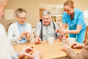Nursing home care for seniors while drinking coffee and playing in the retirement home